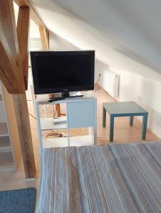 a living room with a flat screen tv on a white table at Gästezimmer in Diedorf