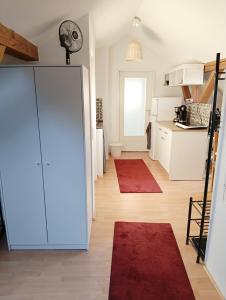 a kitchen with a white refrigerator and red rugs at Gästezimmer in Diedorf
