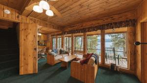 a living room with couches and a table and windows at McCall Lakehouse Private Dock Beach & Grill in McCall