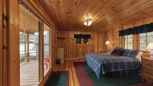a bedroom with a bed in a wooden cabin at McCall Lakehouse Private Dock Beach & Grill in McCall +16 photos