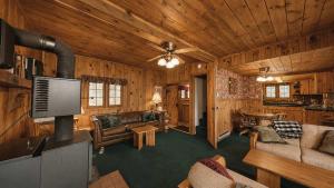 a living room in a log cabin with a tv at McCall Lakehouse Private Dock Beach & Grill in McCall
