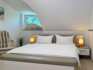 a bedroom with a bed and a chair at Ferienhaus Seegras in Groß Kirr