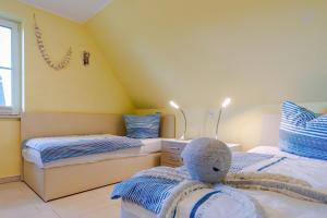 a bedroom with two beds and a stuffed animal sitting on the bed at Ferienhaus Seegras in Groß Kirr