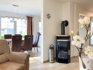 a living room with a fireplace and a dining room at Ferienhaus Seegras in Groß Kirr +10 photos