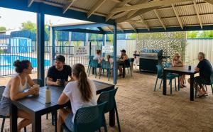 a group of people sitting at tables in a patio at Sails Motel Geraldton in Geraldton
