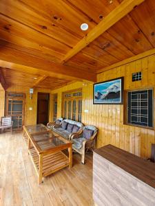 a living room with a couch and a table at Himalaya Vista - 1km Uphill Hike from Main Road in Harsil