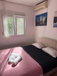 a bedroom with a large bed with two towels on it at Apartman Dunjićeva in Kotor