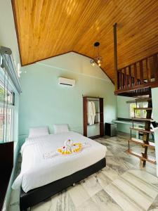 a bedroom with a large bed and a staircase at Highland Park Mondulkiri in Phumĭ Pu Klé (2)