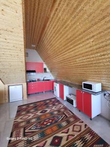 a kitchen with red cabinets and a rug at Shabran Pearl A-Frame in Surra