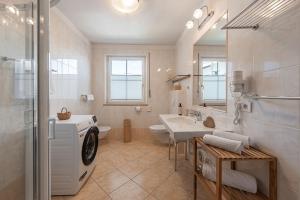 a bathroom with a sink and a washing machine at Tirolerhof - panoramic apartments in Natz-Schabs +68 photos