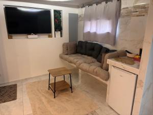 a living room with a couch and a table at Spa Jacuzzi Moon White in Vaudherland +1 photo