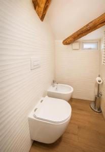 a white bathroom with a toilet and a sink at Una Baita nel Centro di Pescara con Parcheggio Privato - Palazzo Carolina in Pescara +4 photos