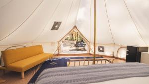 a bedroom in a tent with a bed and a table at Chic Glamping Tent with Firepit in Branson