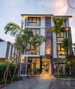 a building with a palm tree in front of it at Pim Old Town in Chiang Mai