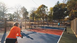 a group of people playing tennis on a tennis court at Chic Glamping Tent with Firepit in Branson