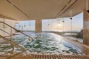 a large plunge pool in a building with large windows at Gordonia Zikhron Ya'akov in Zikhron Ya'akov