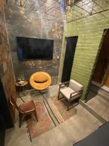 a living room with a chair and a table and a television at BACKHOUSE Vieiralves - Manaus in Manaus