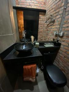 a bathroom with a black sink and a brick wall at BACKHOUSE Vieiralves - Manaus in Manaus
