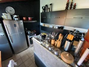 a kitchen with a stainless steel refrigerator and a counter at BACKHOUSE Vieiralves - Manaus in Manaus