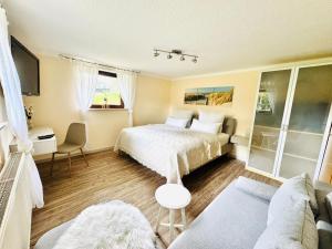 a bedroom with a bed and a couch at Auszeit am Petersdorfer See in Funfseen