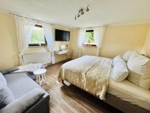 a bedroom with a bed and a desk and two windows at Auszeit am Petersdorfer See in Funfseen