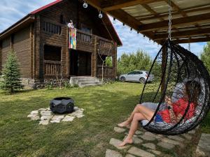a woman sitting in a hammock in a yard at Eco house in Szack