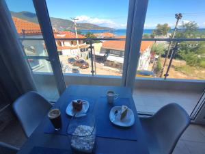a blue table with two plates of food and a window at Celeste Deluxe Apartments in Skala Potamias