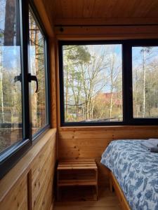 a bedroom with three windows in a log cabin at Zdalnie z Lasu - Siedlisko w Puszczy Białowieskiej in Narewka