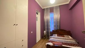 a bedroom with purple walls and a bed at Panorama City Kutaisi in Kutaisi