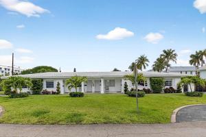 a white house with palm trees in front of it at Marina Row 4 Beach Shops in Delray Beach