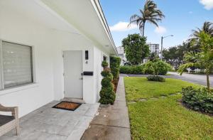 a white house with a door and a grass yard at Marina Row 4 Beach Shops in Delray Beach +22 photos