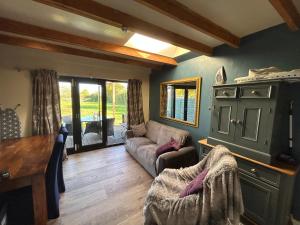 a living room with a couch and a table at Cobblers Lodge in Somersham