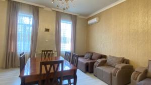 a living room with a table and a couch and a dining room at Panorama City Kutaisi in Kutaisi