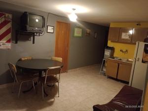 a kitchen and dining room with a table and a tv at Hospedaje DON MANUEL in Paso de Indios