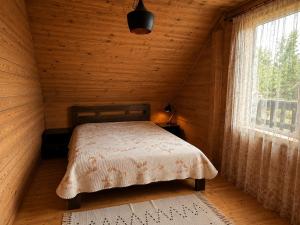 a bedroom with a bed in a wooden cabin at Eco house in Szack