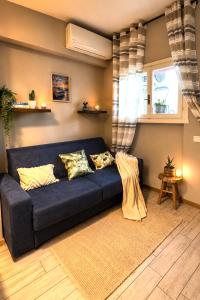 a blue couch in a living room with a window at Aloha Pool Apartment - Free Parking - Sirmione in Desenzano del Garda +22 photos