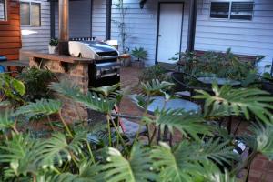 a grill in the yard of a house with plants at Adamsons Riverside in Margaret River Town +109 photos