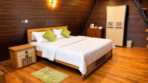 a bedroom with a large bed with green pillows at Ora sigiriya Cabana in Sigiriya