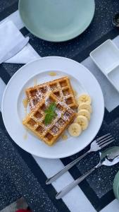 a plate of waffles and bananas on a table at Ora sigiriya Cabana in Sigiriya +43 photos