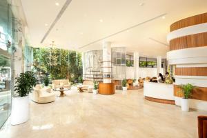 a lobby of a building with tables and chairs at Hotel Explora Calicut by Nova in Kozhikode