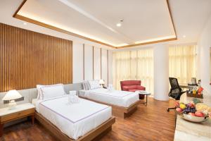 a hotel room with two beds and a couch at Hotel Explora Calicut by Nova in Kozhikode +25 photos