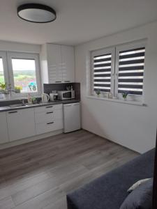 a kitchen with white cabinets and a counter top at Vejminek 87 in Červená Třemešná