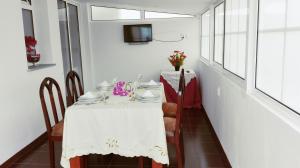 a dining room with a white table and a tv at Mericia's Gorgeous View in Funchal