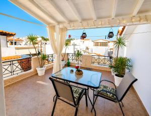 a patio with a glass table and chairs on a balcony at Ιno Skiathos in Skiathos