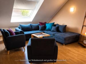 a living room with a blue couch and two chairs at Ostseeferienhaus Usedom Lütow am Achterwasser Hundefreundlich Naturlage Familie Christian Ziethen in Lütow