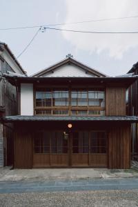 a house with wooden doors and windows on a street at RITA Okawa Hanzakai in Wakatsu