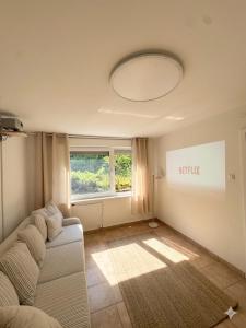 a living room with a couch and a window at Domek letniskowy Wielonek 4 in Cierplewo +6 photos