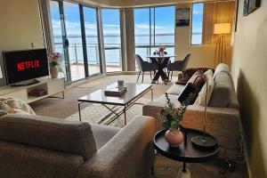 a living room with a view of the ocean at Toukley Waterfront Apartment with Balcony - Outdoor Pool - Secure Parking - Wi-Fi - By HappyHosts in Toukley