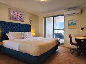 a bedroom with a bed and a desk and a window at Toukley Waterfront Apartment with Balcony - Outdoor Pool - Secure Parking - Wi-Fi - By HappyHosts in Toukley +37 photos