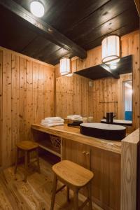 a bathroom with a sink and a counter with two stools at RITA Okawa Hanzakai in Wakatsu
